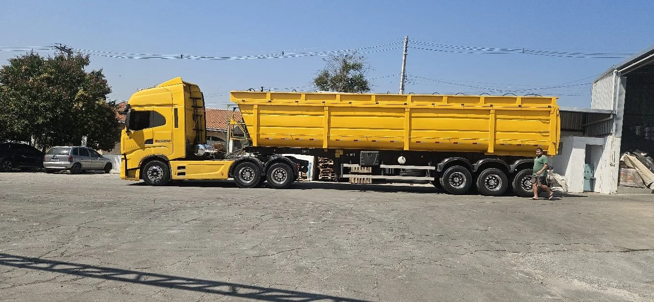 Caminhão com carreta amarela na fábrica